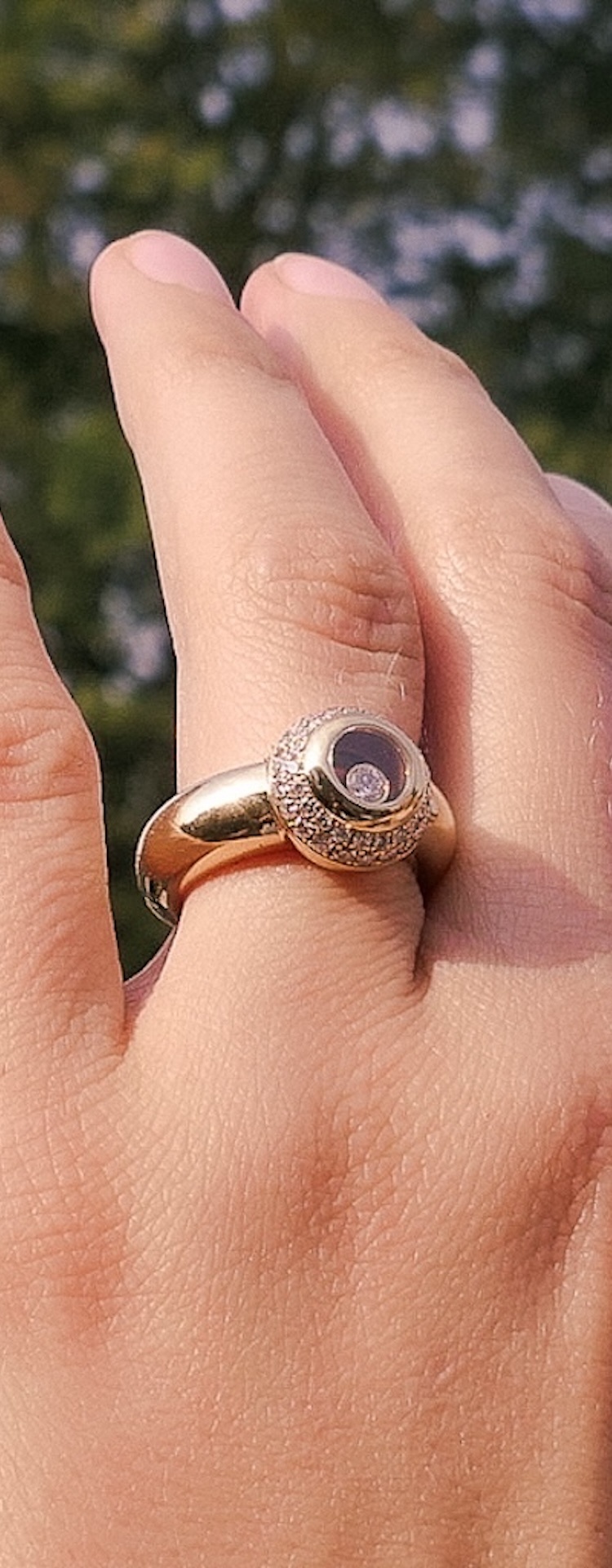 Gouden ring met diamant aan de vinger (foto in de zon gemaakt)