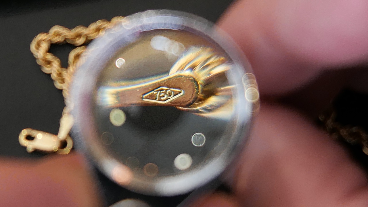 Keurmerk-opzoeken-bij-een-ketting-met-een-loep
